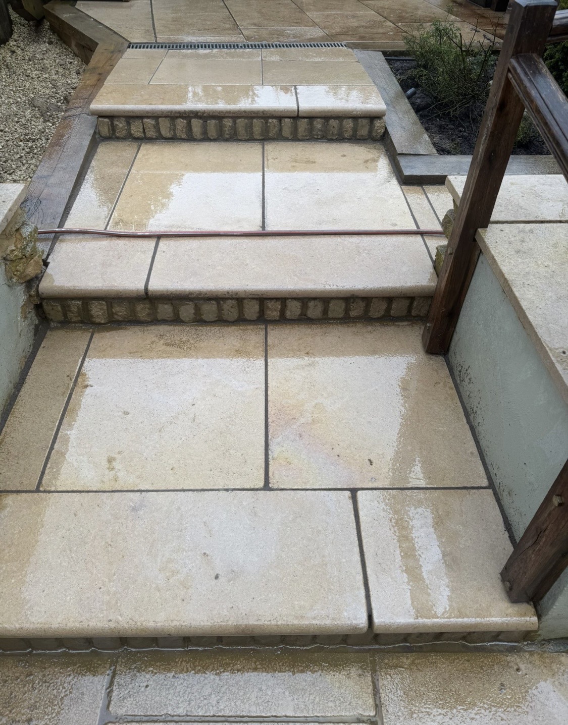 Cream stone garden steps with brick risers and drainage channel