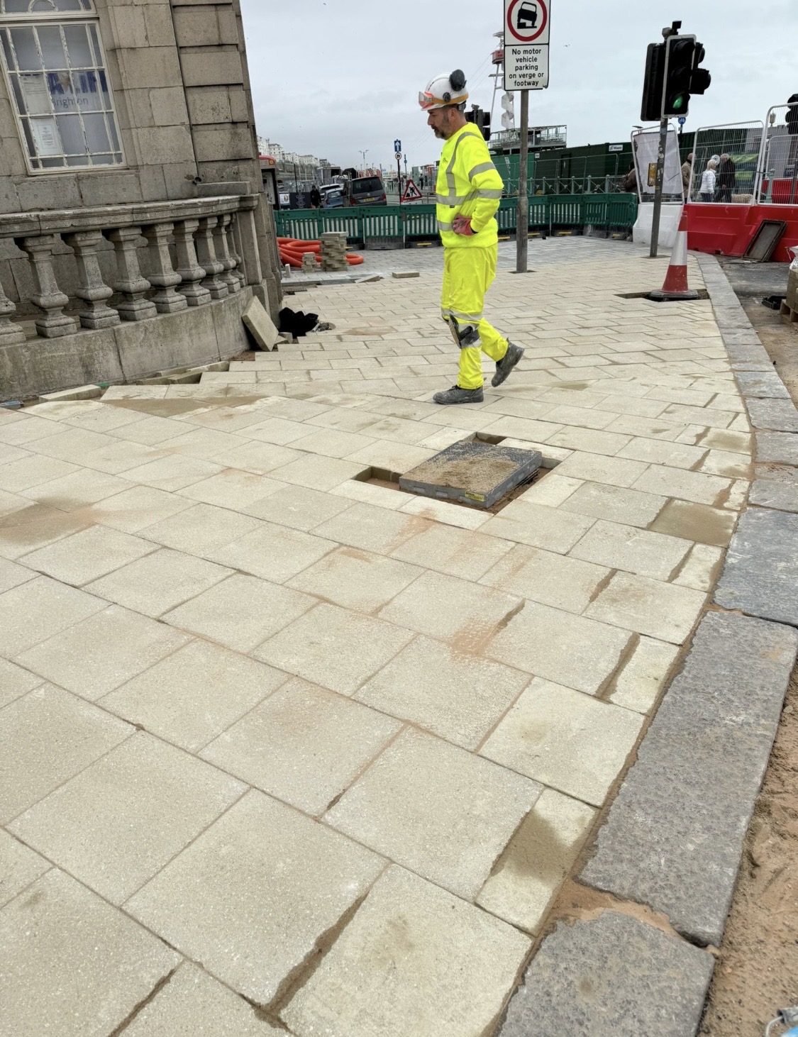 Operative walking across freshly laid sandstone paving on Brighton seafront
