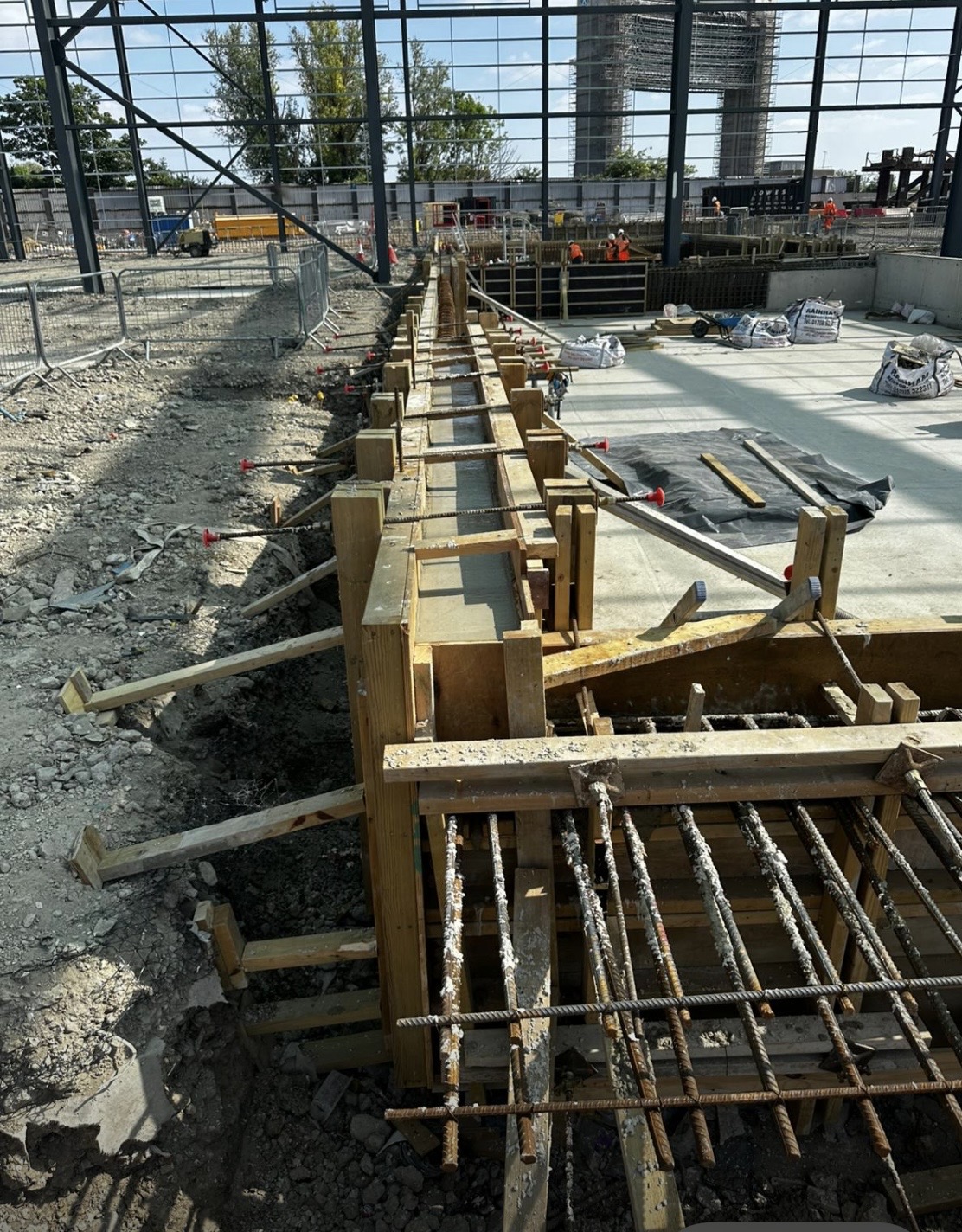 Concrete formwork and reinforcement being set inside a steel frame building