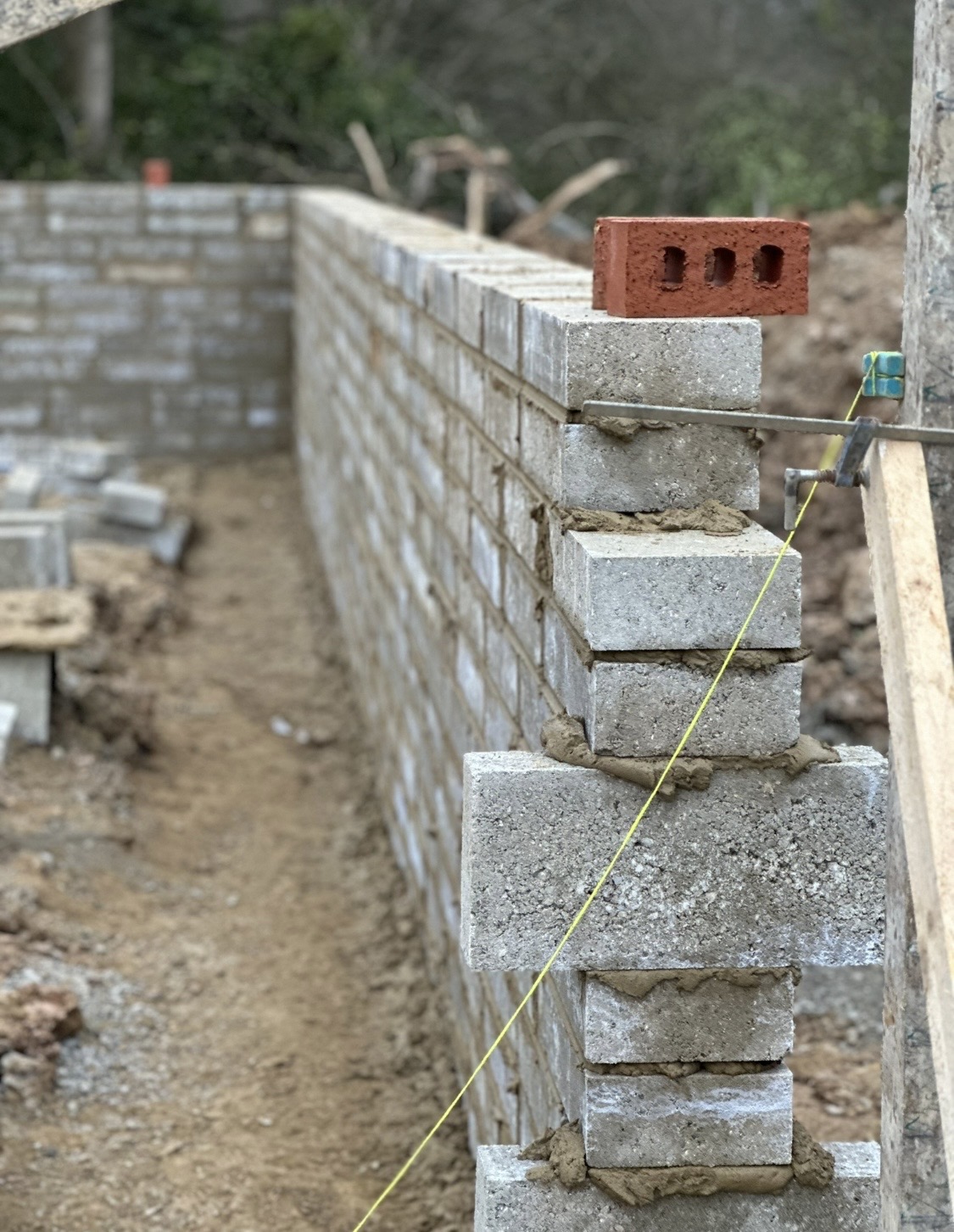 Bricklayer's line and blockwork courses rising on a garden wall
