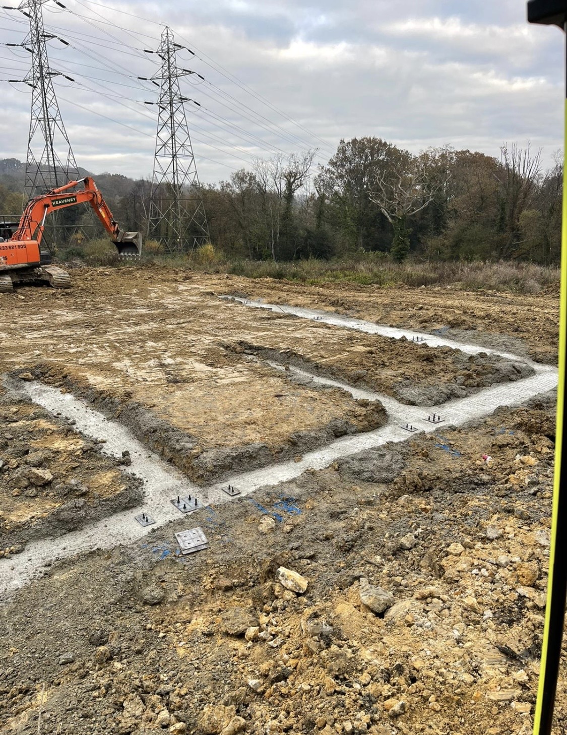 Strip foundations with bolt anchors and pylons in background