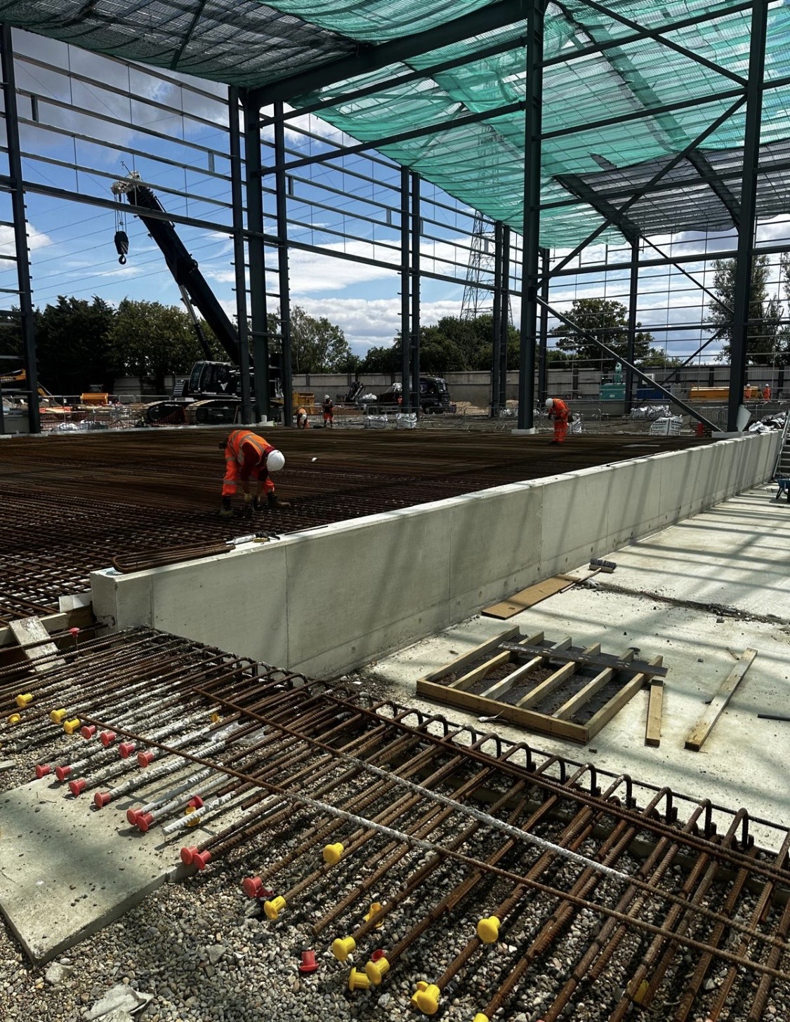 Large slab reinforcement installation underway inside an industrial steel structure