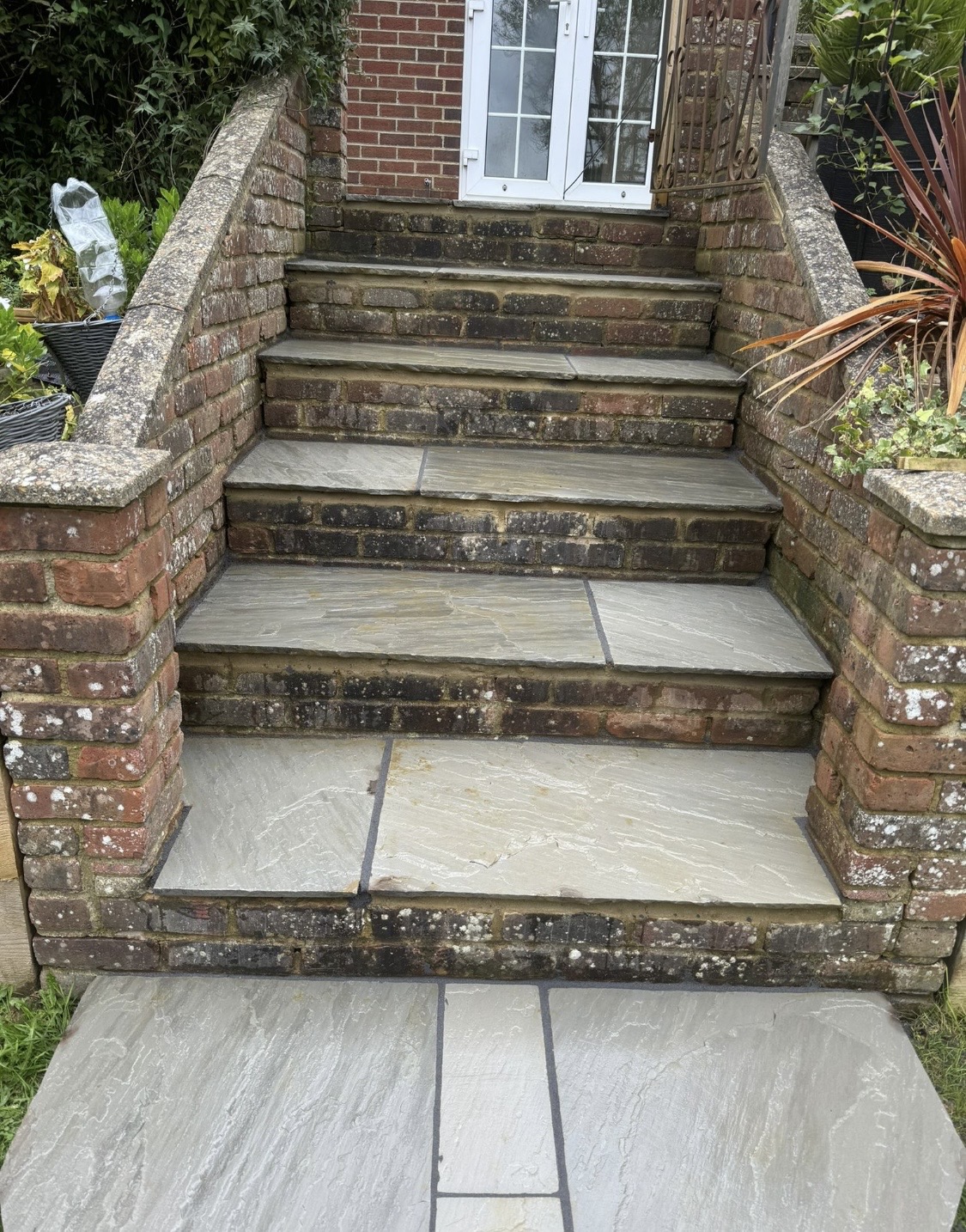 Brick entrance steps finished with grey natural stone paving